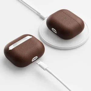 KeyBudz brunt lærdeksel til AirPods 3 vist på en trådløs ladeplate og med en USB-C-kabel tilkoblet.