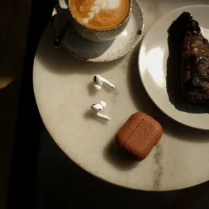 KeyBudz Artisan Series brunt læderetui til AirPods Pro med trådløse øretelefoner på en bordplade