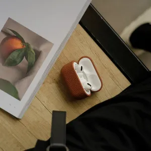 KeyBudz brunt læderetui til AirPods Pro med åbent låg og hvide øretelefoner, vist i et livsstilsmiljø