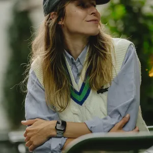 Kvinne utendørs iført en Apple Watch med stripete rem, som viser stilen til KeyBudz Spectra Series.