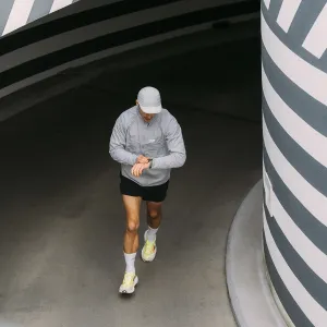 Löpare som bär KeyBudz Journey Apple Watch-armband medan de kontrollerar sin klocka i en utomhustunnel