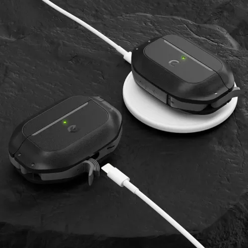 AirPods Pro 2-etuiet i svart vises to ganger, én på en hvit ladeplate, én med åpen portdør og grønn LED, med kabel.