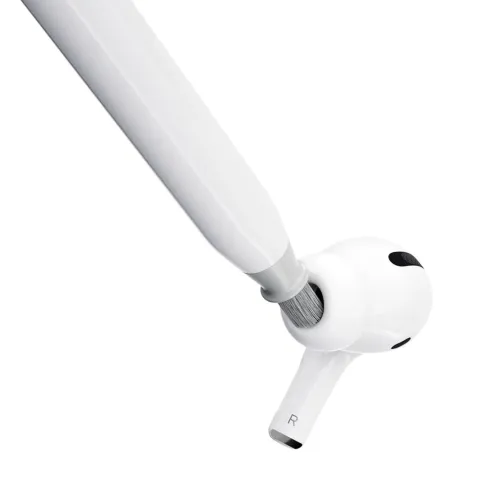 KeyBudz AirCare 2.0 rengøringsbørste børster åbningen på en hvid R-klassificeret øretelefon, nærbillede med børsten i en skrå vinkel.