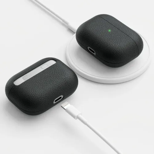 Svart läderfodral för AirPods Pro med stenkornig yta, utskärning för Lightning-port och LED, visat på laddplatta och bord.