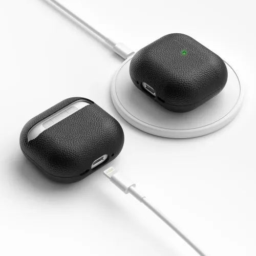Läderfodral för AirPods i svart läder, ett på trådlös laddningsplatta med grön LED och ett bredvid med synlig laddningsport och knappar.