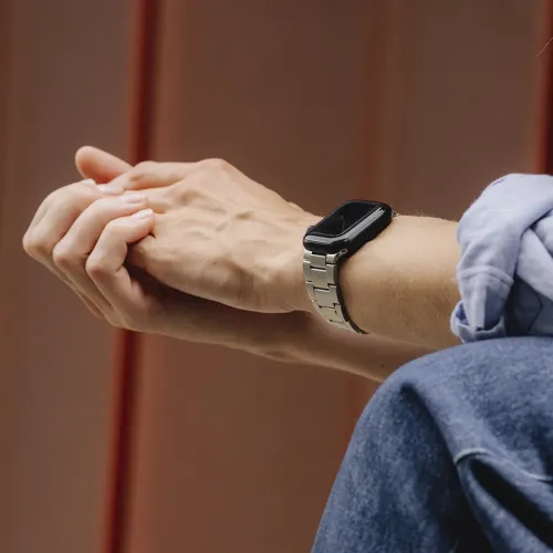 KeyBudz Apple Watch-armband i rostfritt stål med silverfärgad länkdesign, buret på en handled
