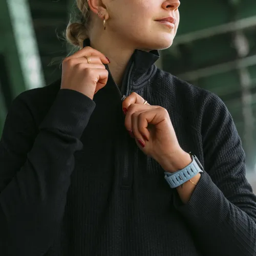 KeyBudz Journey Apple Watch-bånd i Tidal Blue på håndleddet, perforert bånd med pin-and-tuck, sett fra siden i nærbilde.
