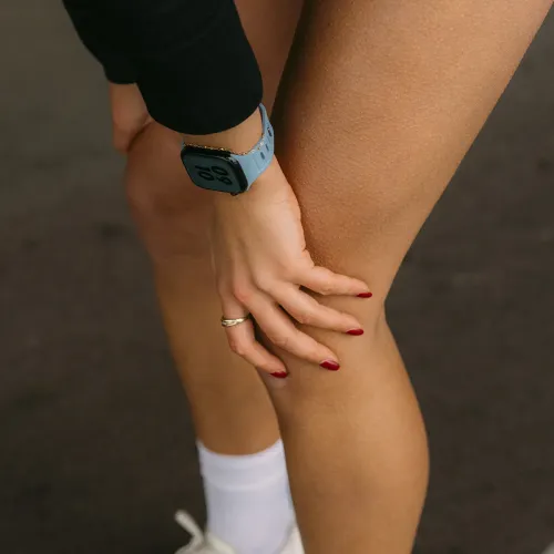 KeyBudz Journey Apple Watch-bånd i Tidal Blue på håndleddet; perforert bånd med avrundede hull, klokkekant synlig, fra hånd til lår.