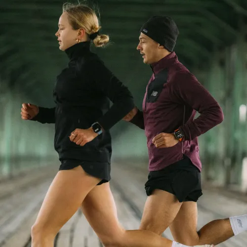 KeyBudz Journey Apple Watch-båndet i elektrisk oransje vises på løperens håndledd, i sideprofil med rektangulær urskive.