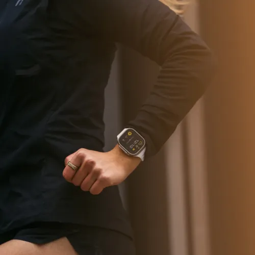 Kiviharmaa Apple Watch -ranneke ranteessa juostessa; sileä ranneke näkyy selvästi kiinnitettynä suorakulmaiseen kelloon lähikuvassa lähikuvassa.